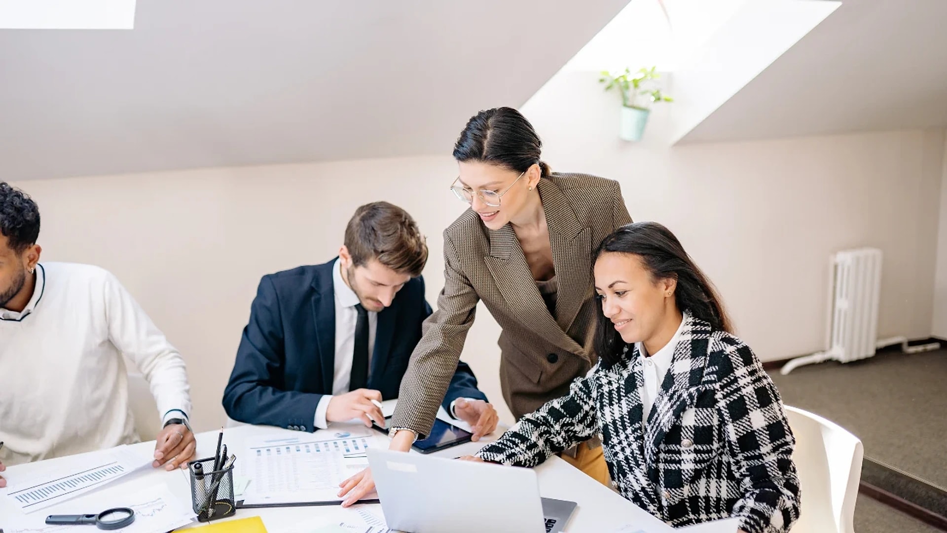 A team reviewing documents together beside a laptop