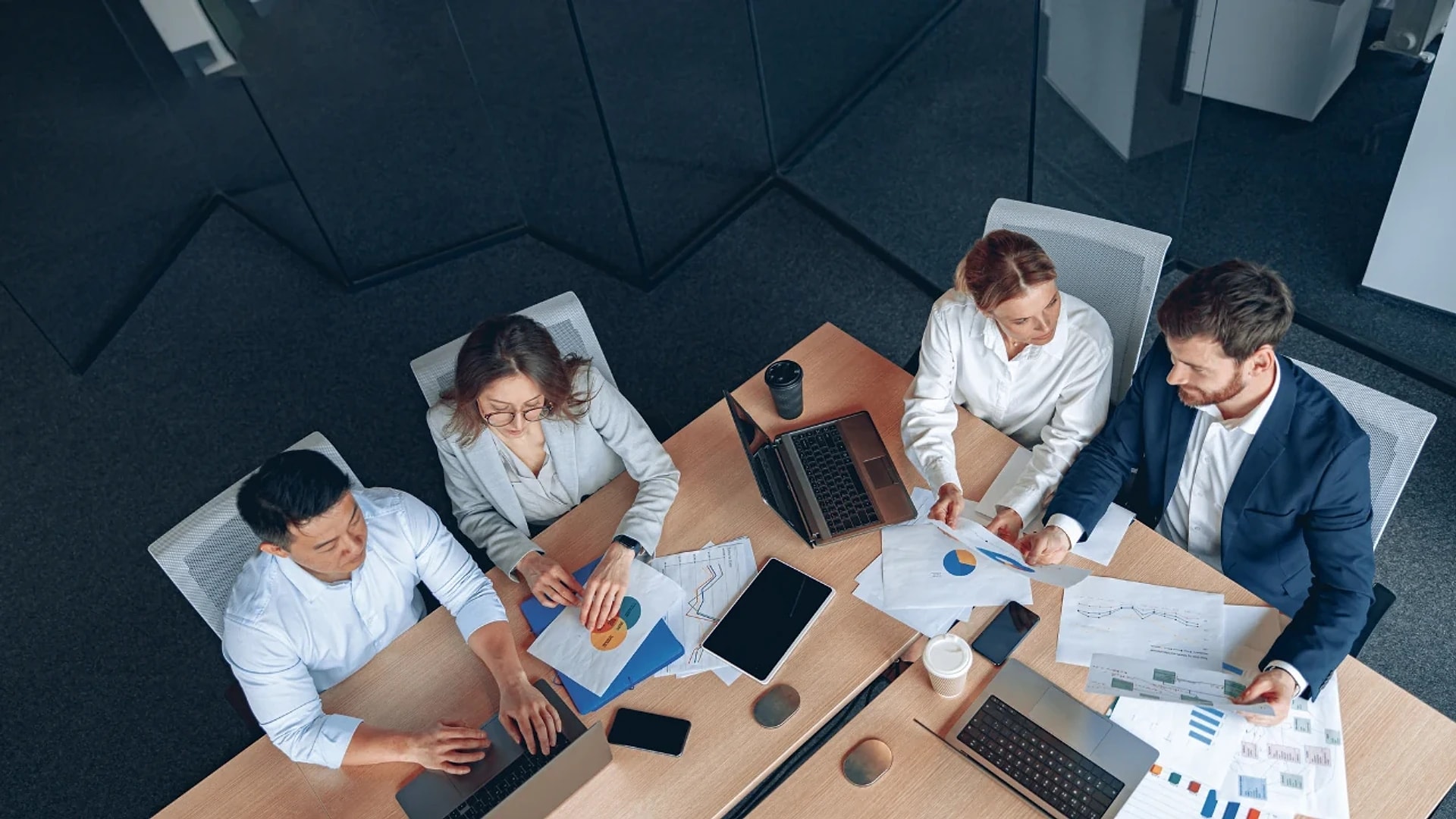 An overhead view of colleagues reviewing documents around a meeting table